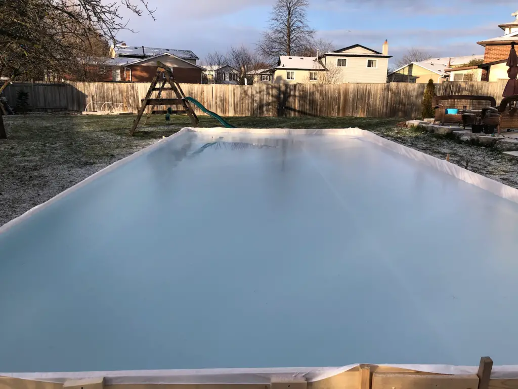 filling a backyard ice rink with water