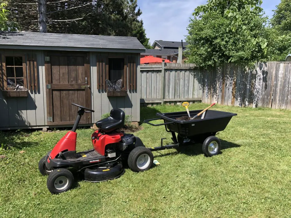 dump cart and rear engine riding lawnmower with custom hitch to maintain a backyard